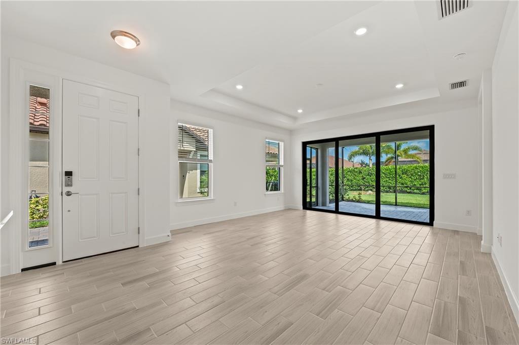 15517 Vittorio Street Naples, FL 34114 - Photo 2 of 35 Entryway featuring baseboards, light wood-type flooring, a raised ceiling, and recessed lighting