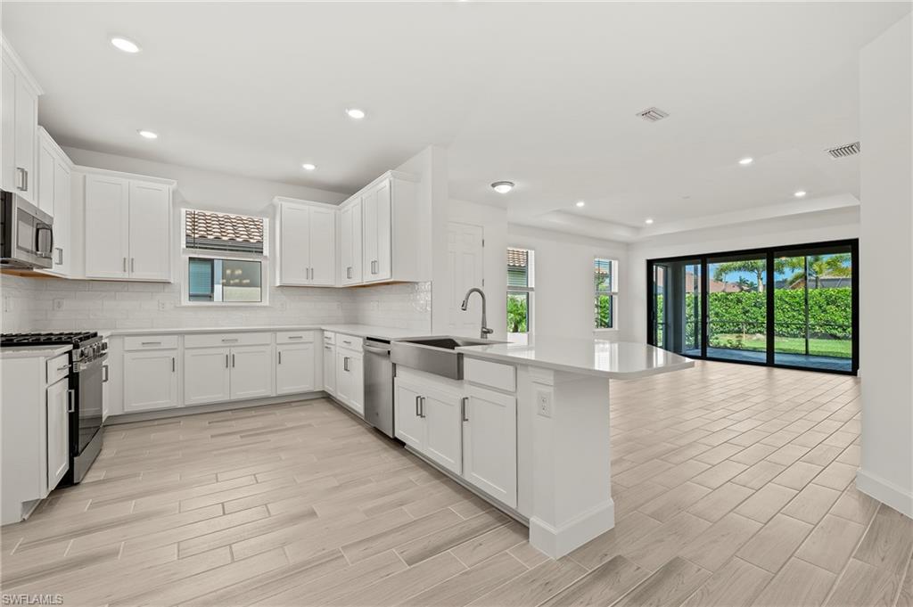 15517 Vittorio Street Naples, FL 34114 - Photo 5 of 35 Kitchen featuring a sink, appliances with stainless steel finishes, a peninsula, plenty of natural light, and recessed lighting