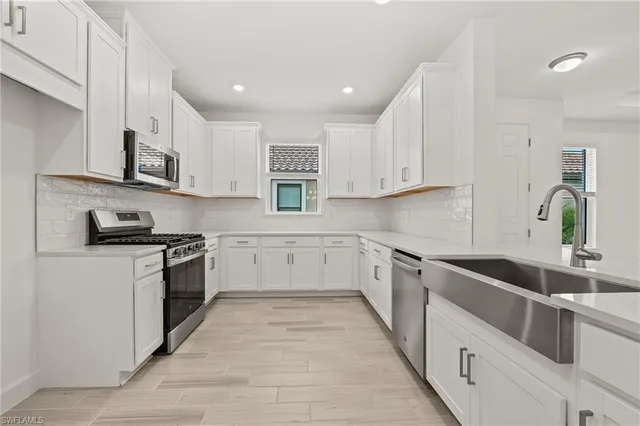 a kitchen with stainless steel appliances granite countertop a sink and cabinets