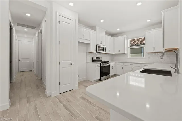 a kitchen with stainless steel appliances a sink a stove a refrigerator and cabinets