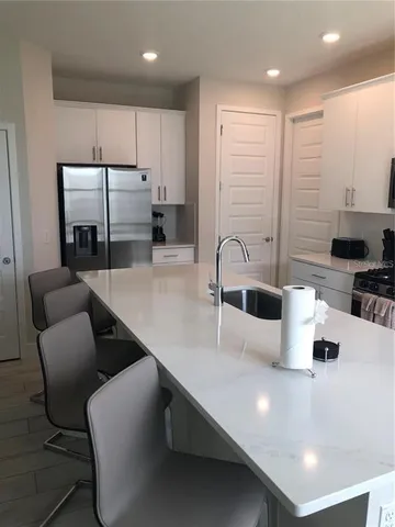 a kitchen with stainless steel appliances a sink a table and chairs