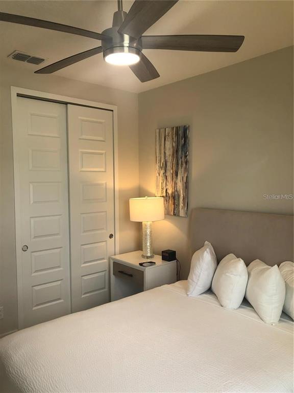 820 Driving Range Court Reunion, FL 34747 - Photo 27 of 45 a bedroom with a bed and a chandelier
