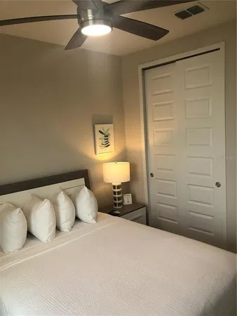a bedroom with a bed and a ceiling fan