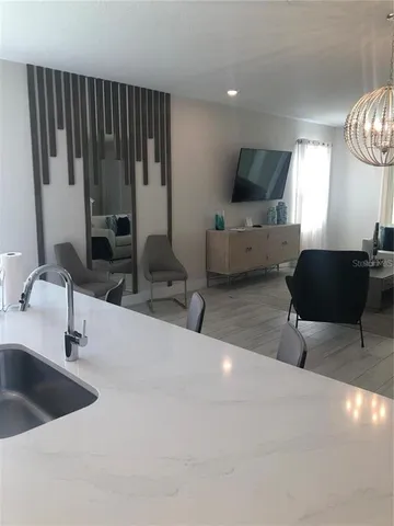 a kitchen with stainless steel appliances a sink a microwave a refrigerator and cabinets