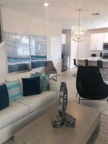 a living room with furniture chandelier and a large window