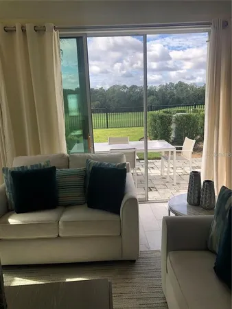 a living room with couch and a floor to ceiling window