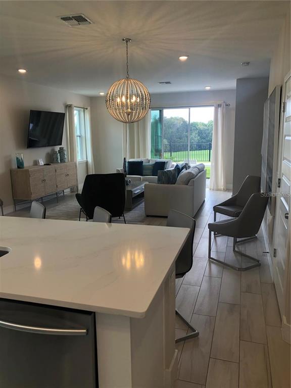 820 Driving Range Court Reunion, FL 34747 - Photo 10 of 45 a living room with furniture a chandelier and a flat screen tv