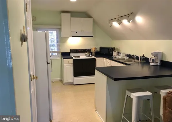 a kitchen with stainless steel appliances granite countertop a refrigerator a stove and a sink