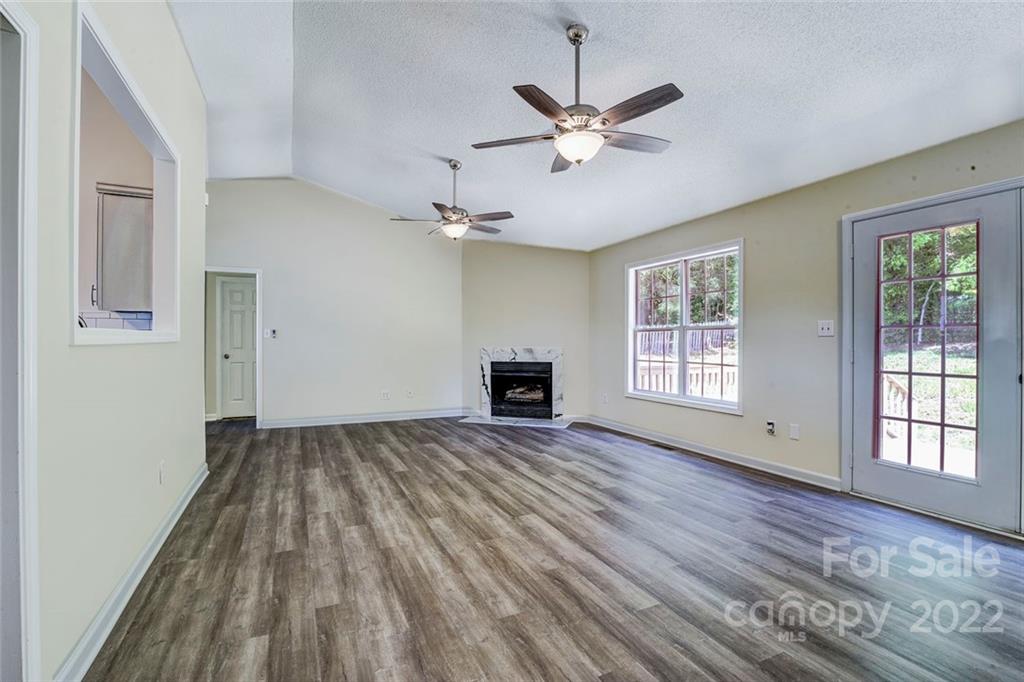 1022 Piney Church Road Concord, NC 28025 - Photo 4 of 16 a view of an empty room with wooden floor fireplace and a window