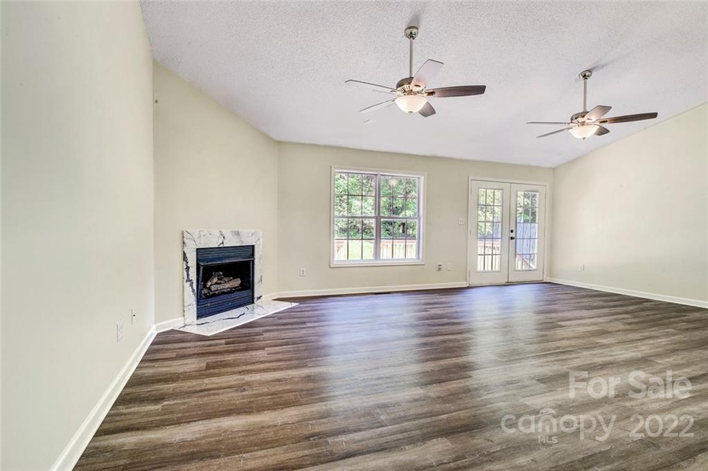 1022 Piney Church Road Concord, NC 28025 - Photo 5 of 16 an empty room with wooden floor chandelier and windows