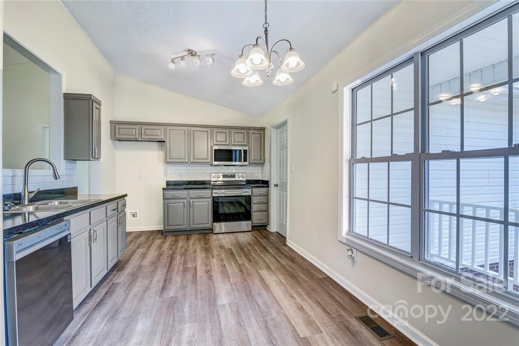 1022 Piney Church Road Concord, NC 28025 - Photo 6 of 16 a kitchen with stainless steel appliances a stove sink and cabinets
