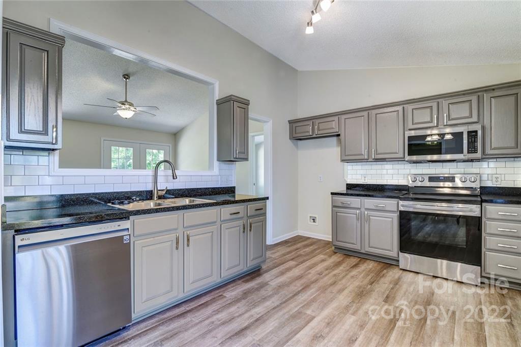 1022 Piney Church Road Concord, NC 28025 - Photo 8 of 16 a kitchen with stainless steel appliances granite countertop a stove a sink and a microwave