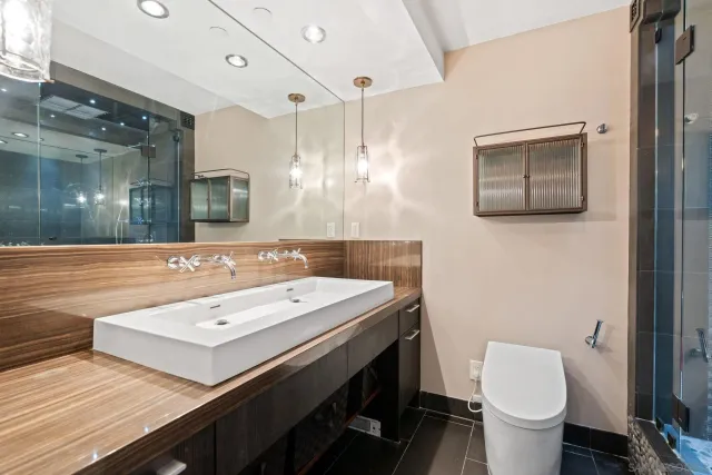 a bathroom with a double vanity sink mirror and shower