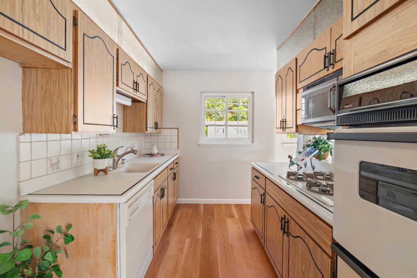 1212 Seville Drive Pacifica, CA 94044 - Photo 13 of 37 a kitchen with stainless steel appliances a sink a stove and a window