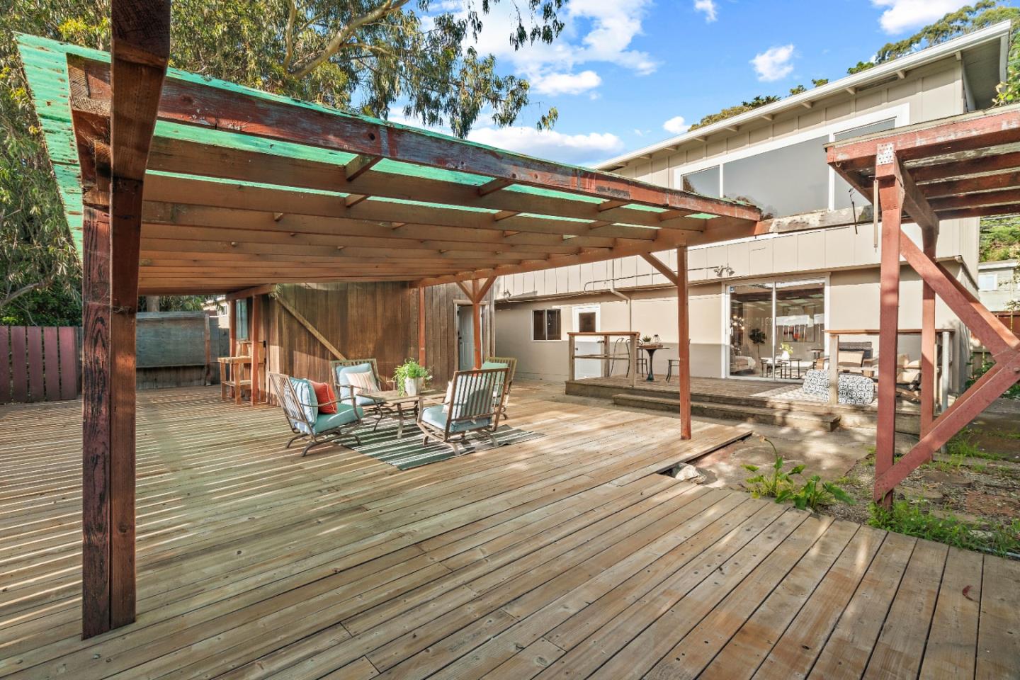 1212 Seville Drive Pacifica, CA 94044 - Photo 25 of 37 a view of a patio with table and chairs with wooden floor and fence