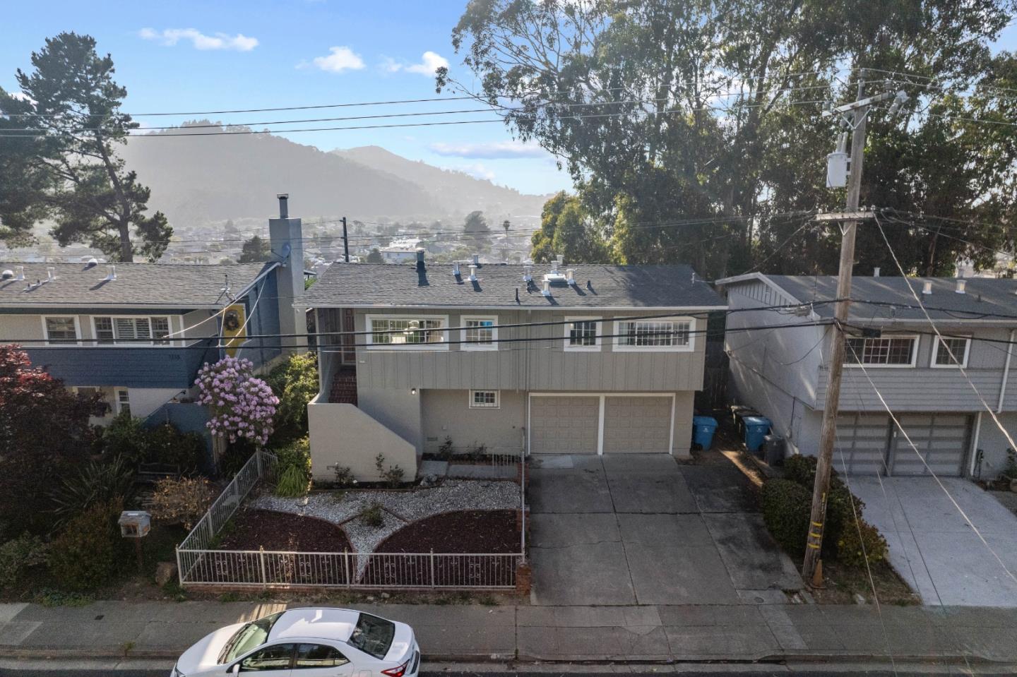 1212 Seville Drive Pacifica, CA 94044 - Photo 31 of 37 a front view of a house with a yard and mountain view in back