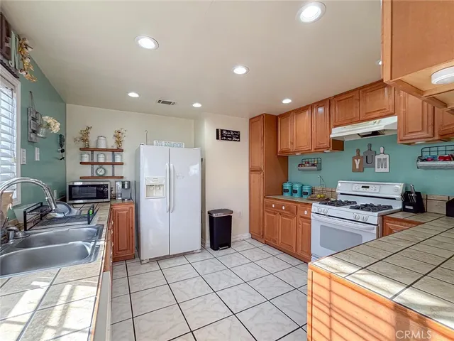 a kitchen with stainless steel appliances granite countertop a refrigerator and a stove top oven
