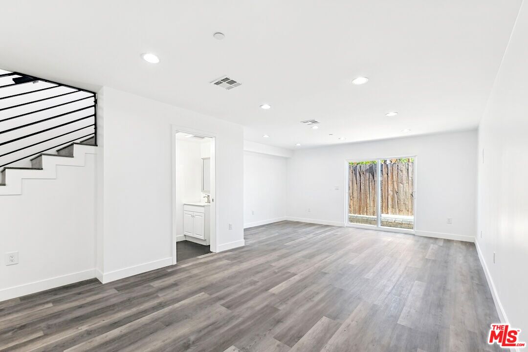 17610 Sherman Way, Unit 3 Van Nuys, CA 91406 - Photo 2 of 19 an empty room with wooden floor and windows