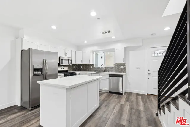 a kitchen with refrigerator cabinets and wooden floor