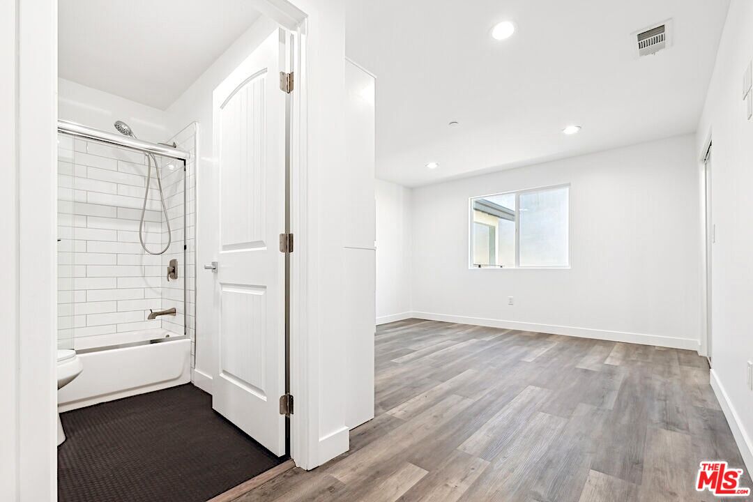 17610 Sherman Way, Unit 3 Van Nuys, CA 91406 - Photo 9 of 19 a view of an empty room with wooden floor and a bathroom