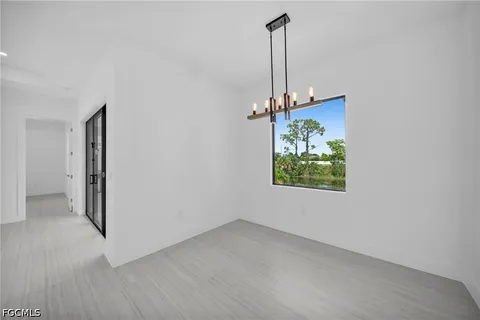 an empty room with a window and a ceiling fan