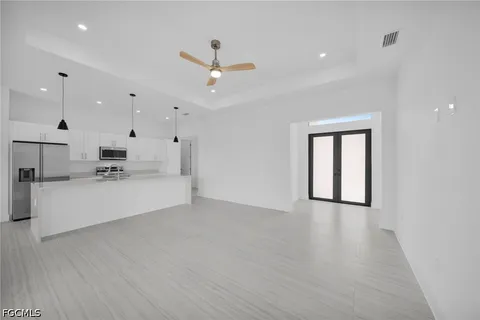 a large kitchen with stainless steel appliances a large counter top a stove and a window