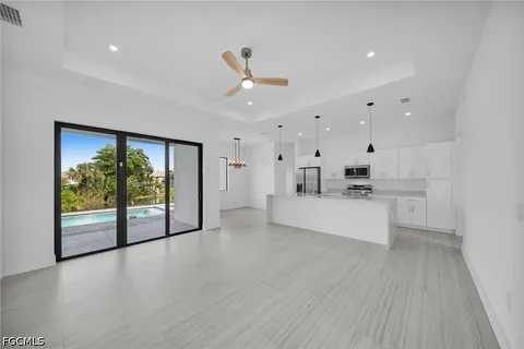 a kitchen with stainless steel appliances a stove a sink a refrigerator a center island and a window
