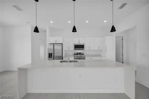 a kitchen with stainless steel appliances granite countertop a sink a stove and a refrigerator