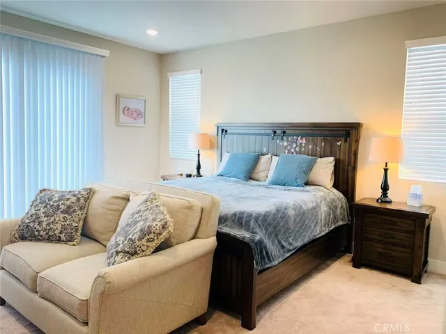 a bedroom with a bed couch and window