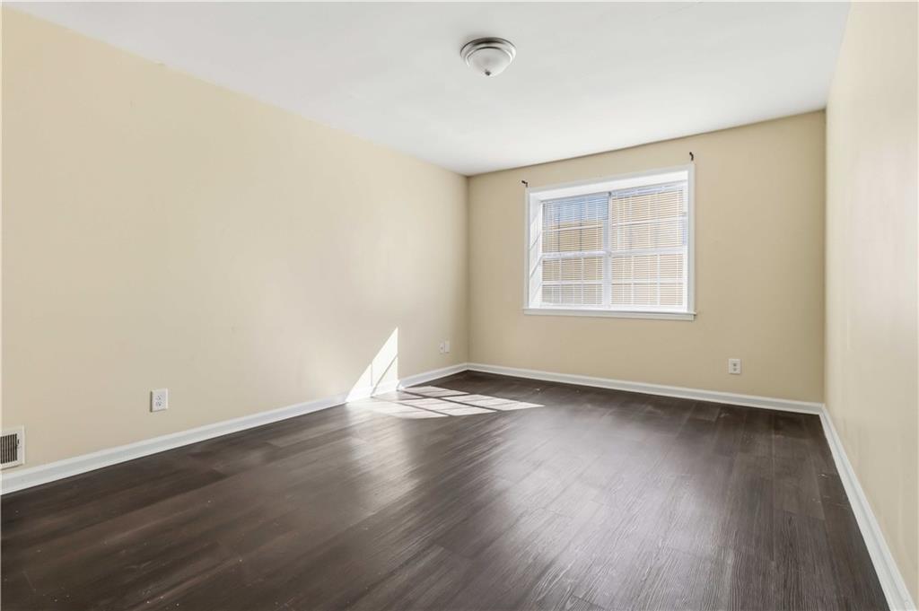 119 Plantation Circle Clarkston, GA 30021 - Photo 18 of 25 an empty room with wooden floor and windows