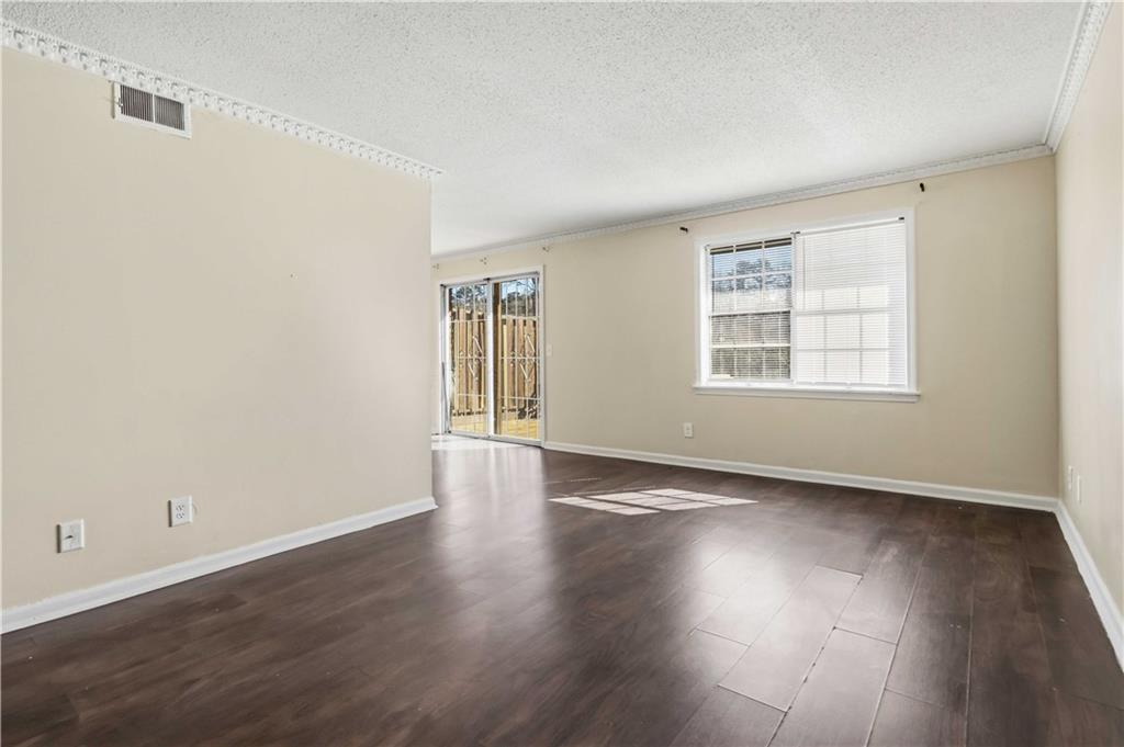 119 Plantation Circle Clarkston, GA 30021 - Photo 6 of 25 an empty room with wooden floor and windows