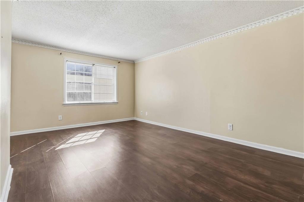 119 Plantation Circle Clarkston, GA 30021 - Photo 9 of 25 an empty room with wooden floor and windows