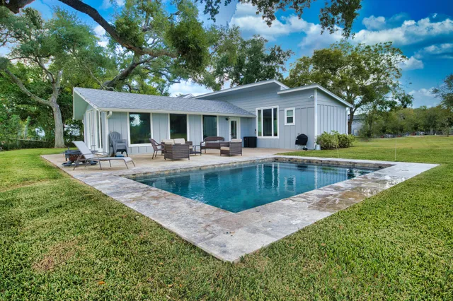 a view of a house with pool and a yard