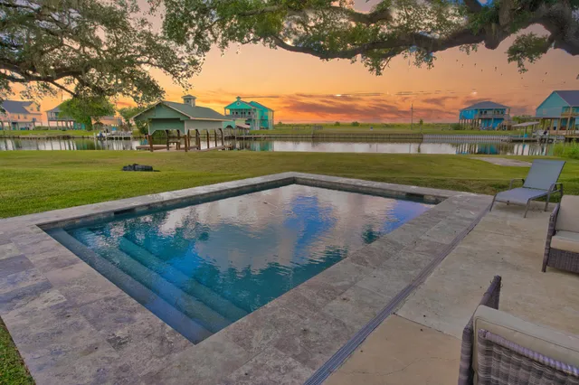 a view of a house with a swimming pool and a chairs