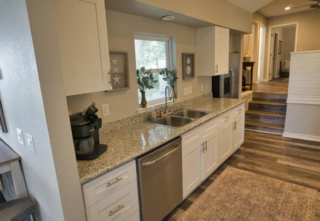 a spacious bathroom with a granite countertop sink and a mirror