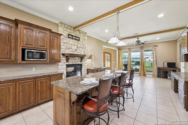 a open kitchen with stainless steel appliances granite countertop wooden floor a dining table and chairs