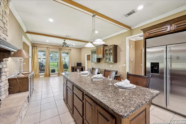 a large kitchen with kitchen island a large counter space a sink appliances and living room view