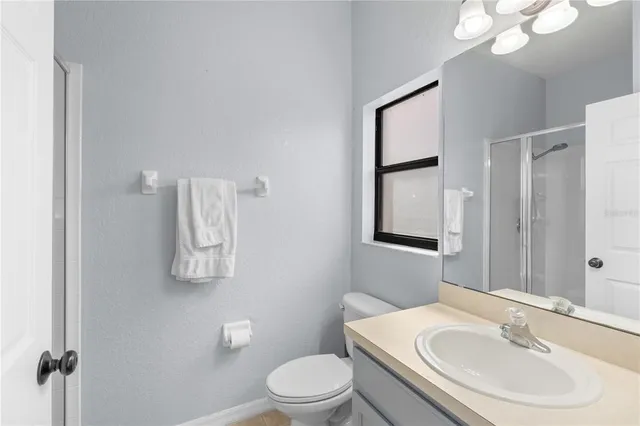 a bathroom with a sink vanity mirror and toilet