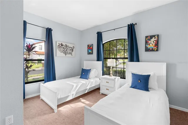 a bedroom with two beds and painting on the wall