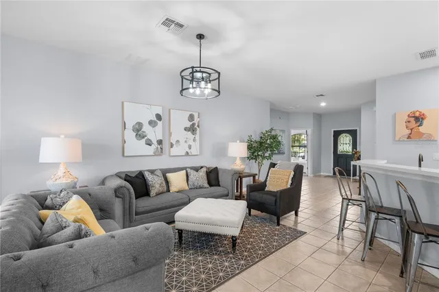 a living room with furniture potted plant and white walls