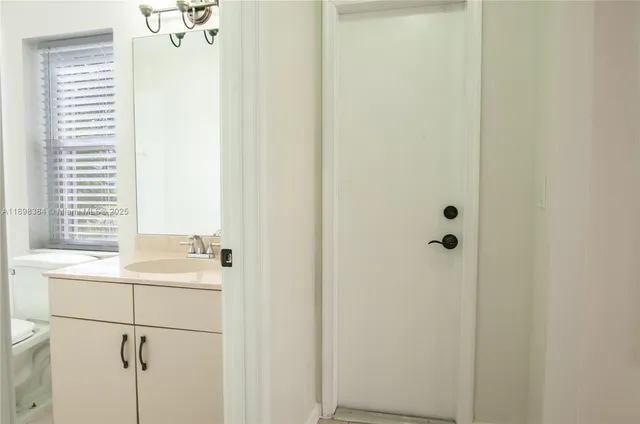 a bathroom with a sink and mirror with bathtub