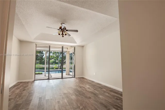 an empty room with wooden floor and balcony