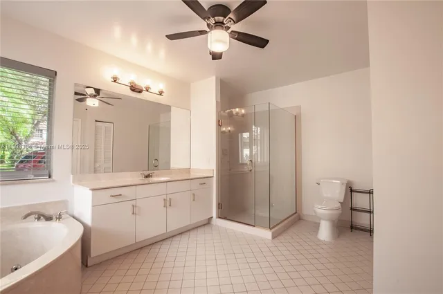 a bathroom with a sink a toilet a mirror and shower