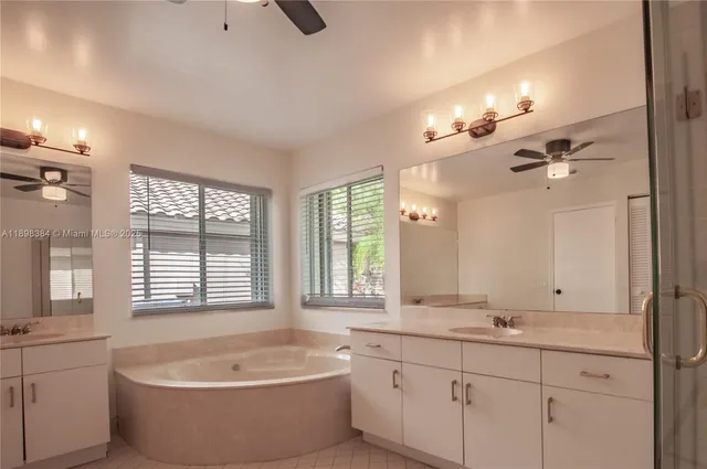 a bathroom with a large tub sink shower double vanity