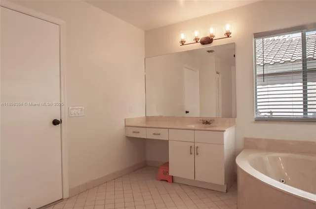a bathroom with a tub sink and mirror