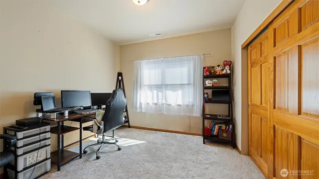 a bedroom with a bed a dresser and potted plant