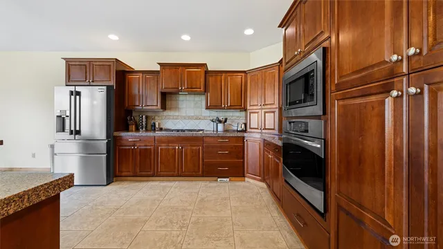 a kitchen with stainless steel appliances granite countertop a refrigerator and a sink