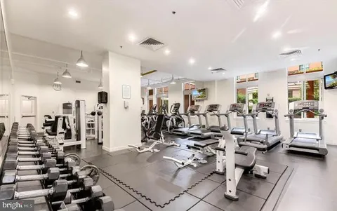 a room with lots of white furniture and potted plants