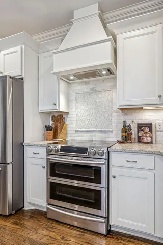 a kitchen with stainless steel appliances a stove a sink and a refrigerator