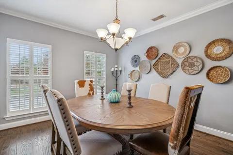 a hallway with wooden floor and a potted plant